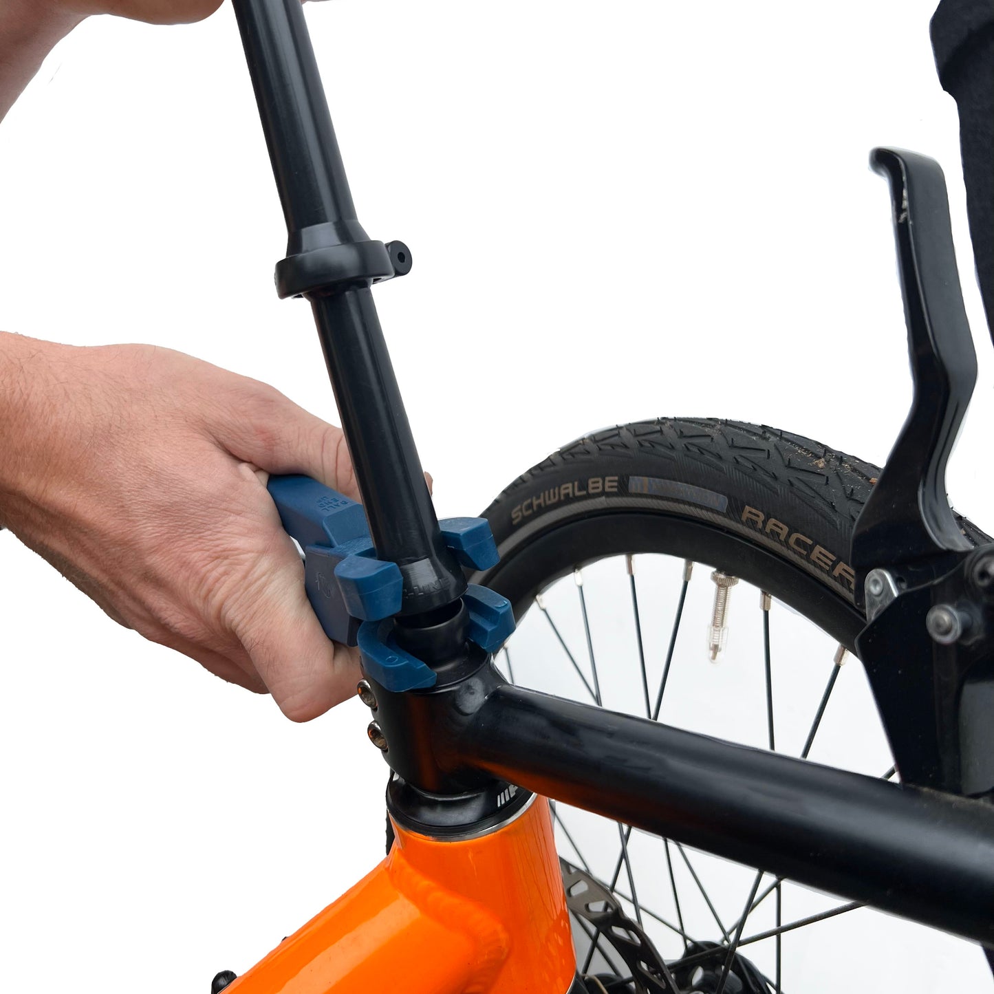 Close-up of a person using Loc-Line Assembly Pliers to connect pieces from the LAMA collection on an orange trike on a white background