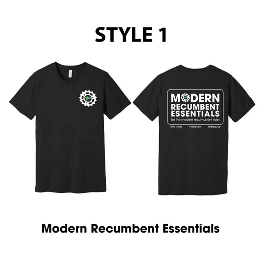 Front and back of black short-sleeve T-shirt shown on a white background, labeled STYLE 1. The left front side shows a small white circular gear logo on the chest, and the right back side of the shirt shows a large white rectangular graphic reading 'MODERN RECUMBENT ESSENTIALS' with "for the modern recumbent rider" in smaller text below.