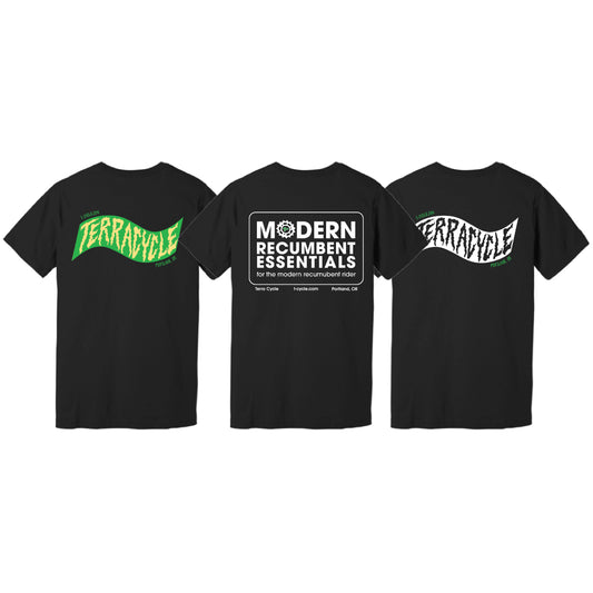 Three black short-sleeve T-shirts shown against a white background, displaying the backs of three design options. The left shirt features a green and yellow wavy 'TERRACYCLE' graphic, the middle features a large rectangle with rounded corners with 'MODERN RECUMBENT ESSENTIALS for the modern recumbent rider' centered inside, and the right shows a white and black wavy 'TERRACYCLE' logo.